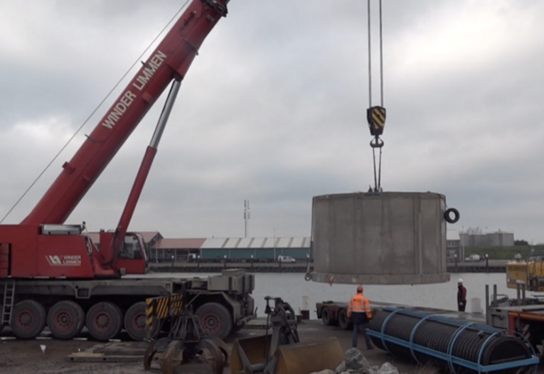 Huge slab of concrete about to be dropped in the water.